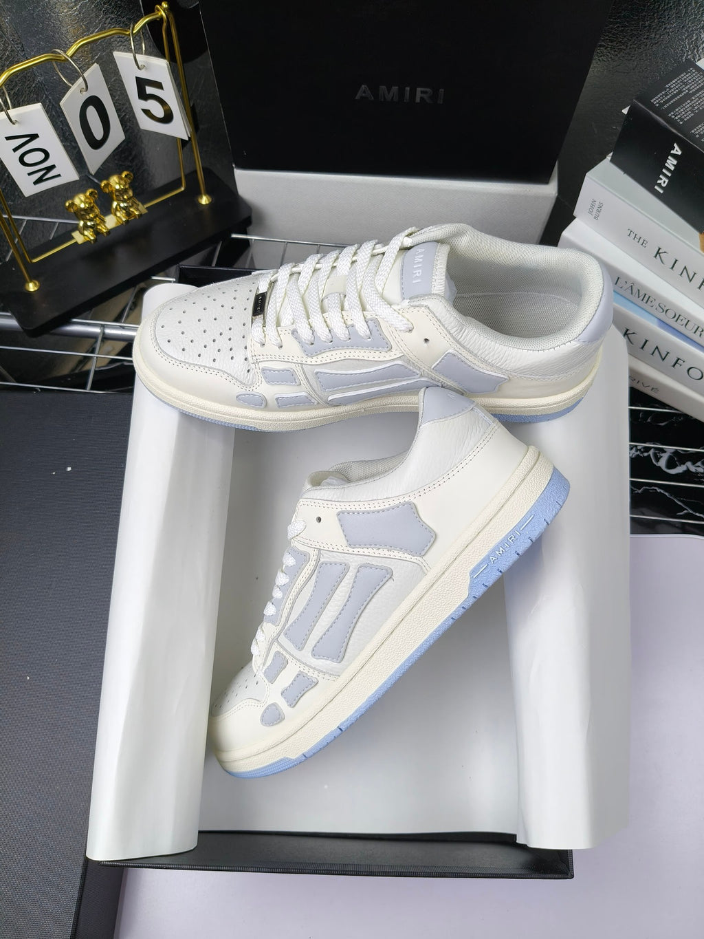 Amiri lace-up sneakers pair, white leather with light-blue logo and lace overlays