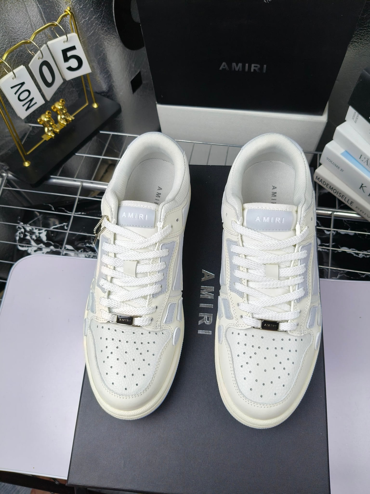 Amiri lace-up sneakers pair, white leather uppers with blue logo accents