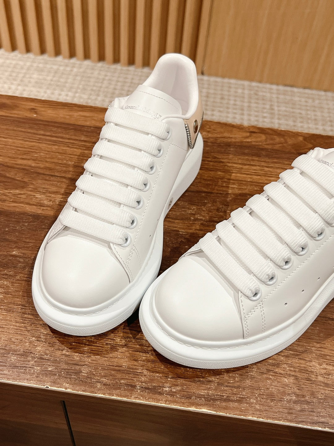Two white lace-up sneakers showing side profile and padded tongue, Alexander McQueen