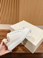 White leather sneakers with lace-up eyelets and low-profile rubber sole, Alexander McQueen