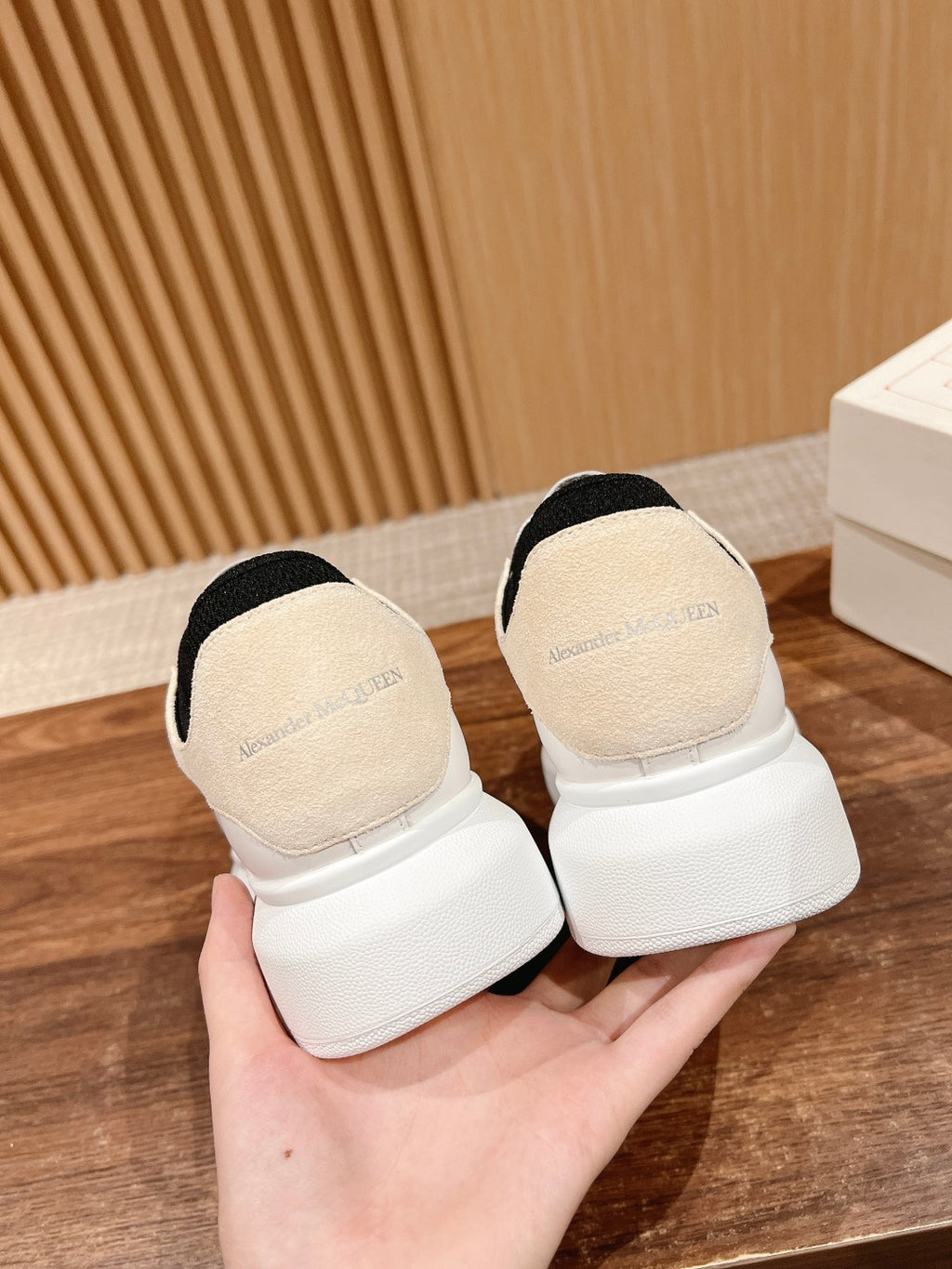 Back view of white low-top sneakers with black heel lining