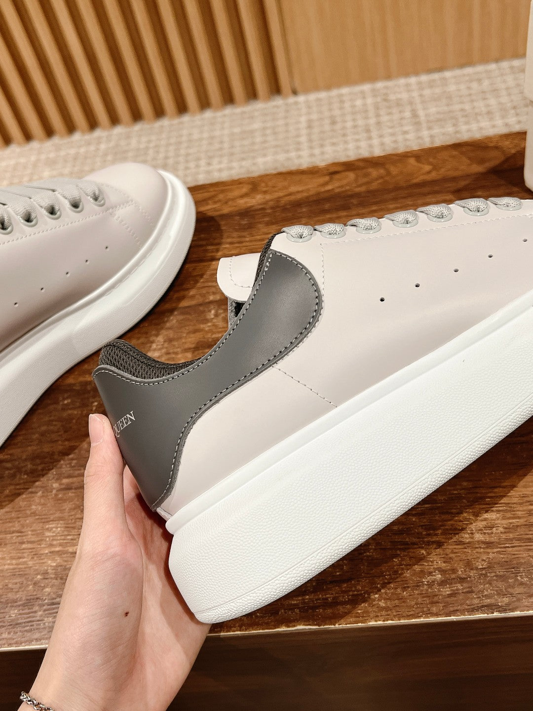 White and gray low-top sneaker with black collar and lace-up closure
