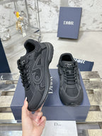 Charcoal gray lace-up sneakers, one held in hand over a blue display box