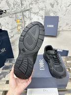 Charcoal gray sneaker outsole with tread pattern, held above a blue box