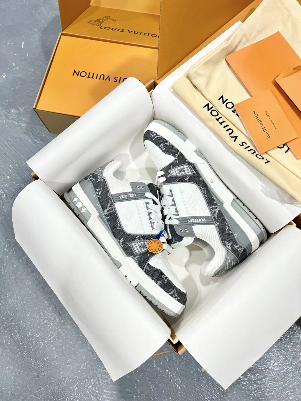 White and dark monogram Louis Vuitton trainer shoes, lace-up with decorative pull tab.