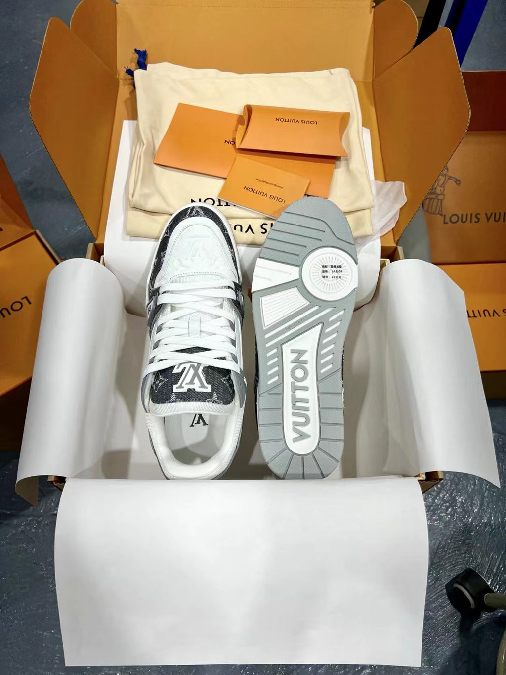 Louis Vuitton trainer shoes with white uppers and dark monogram outsole tread, lace-up.
