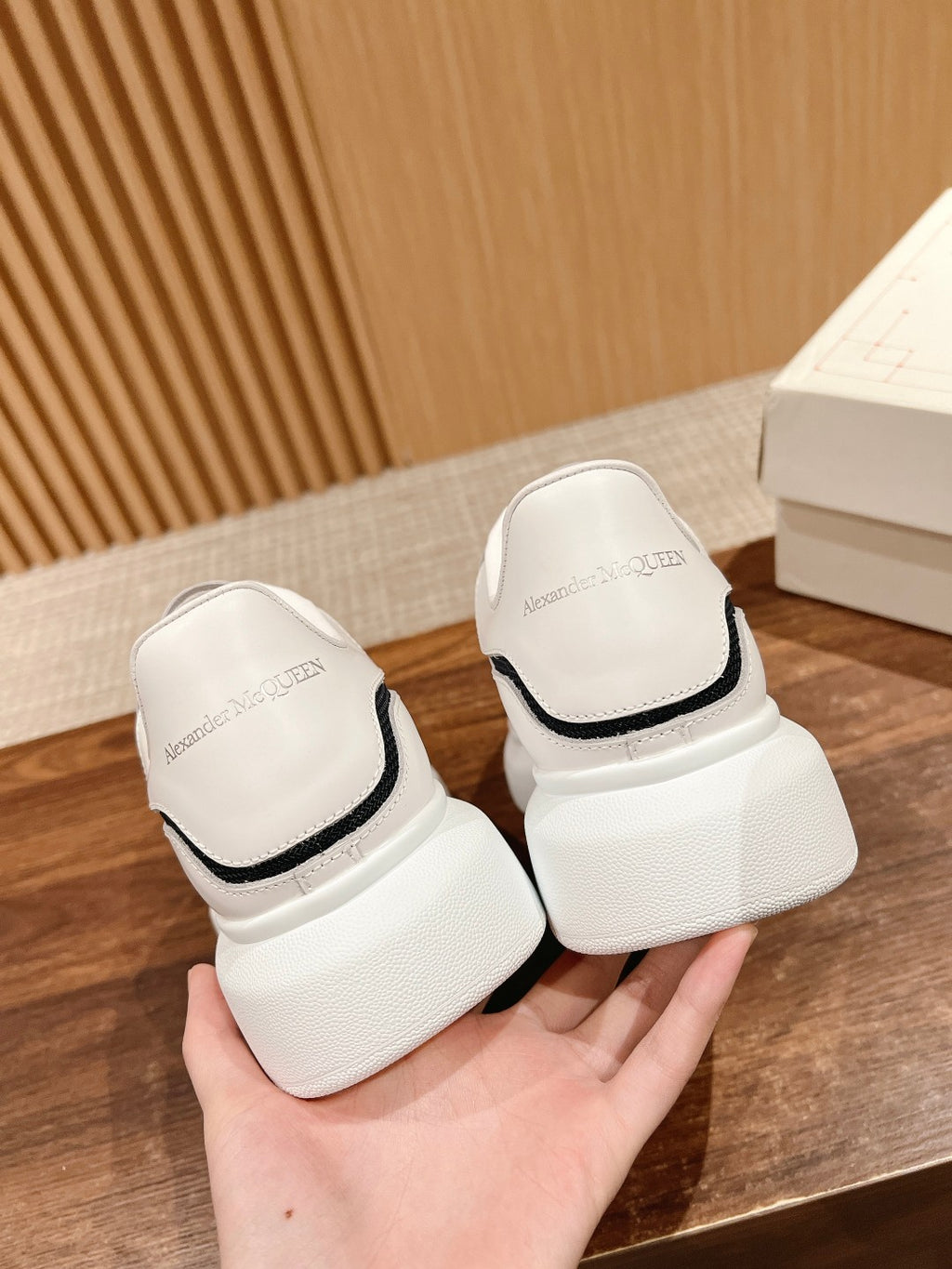 Back view of white sneakers with black heel trim and cushioned platform sole