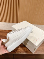 White leather lace-up sneakers with textured sole and side detailing
