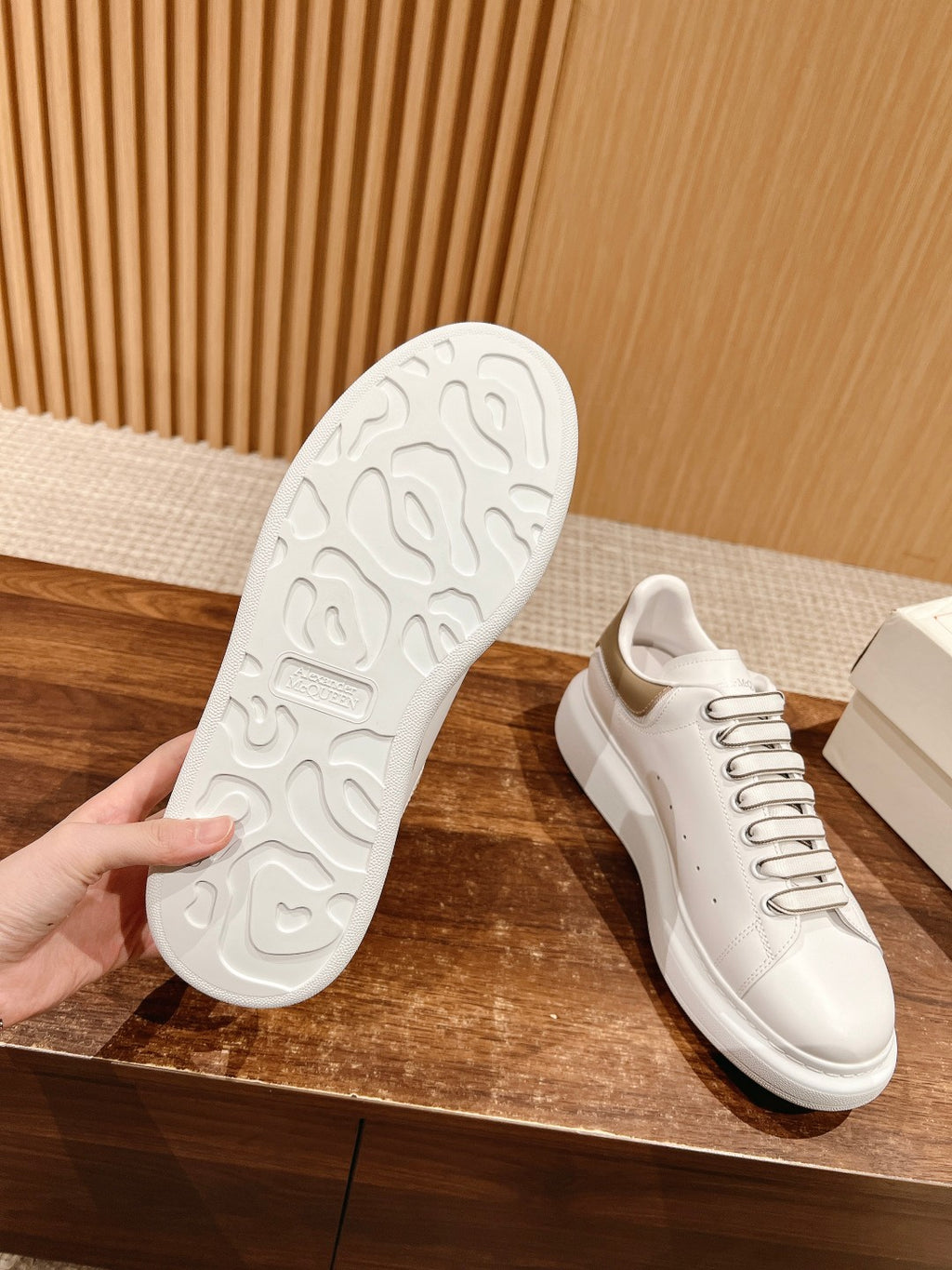 White sneaker outsole view with textured tread and lace-up upper