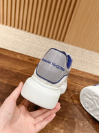 Alexander McQueen sneakers heel view, white with blue logo badge