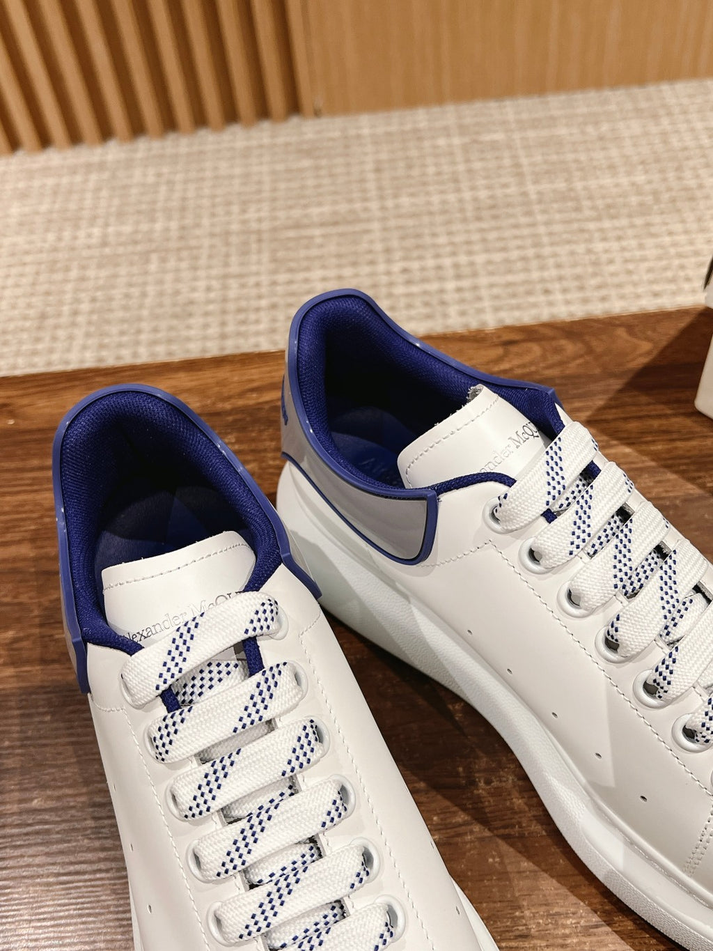Alexander McQueen low-top sneakers pair, white with blue collar and check laces