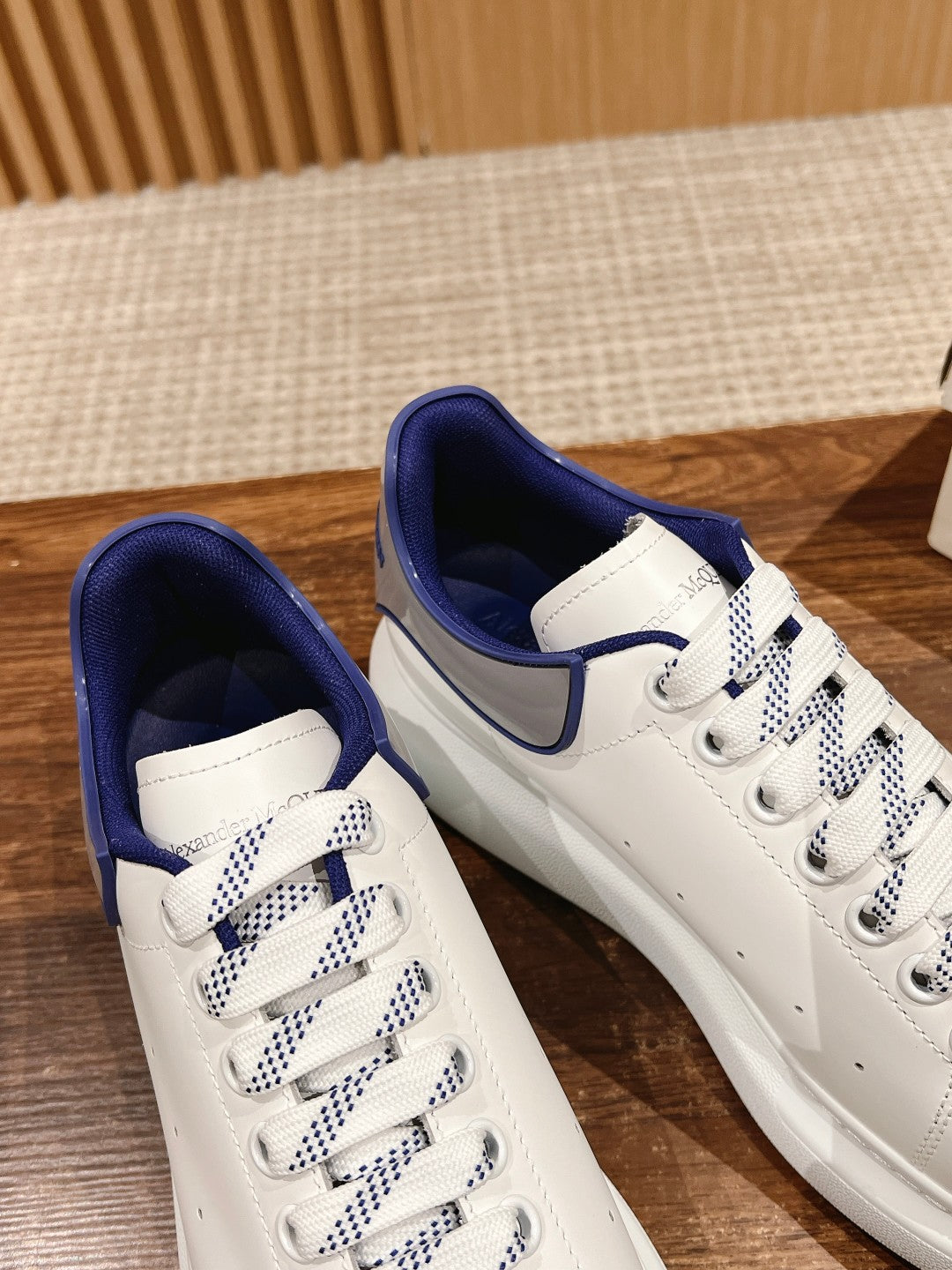 Alexander McQueen low-top sneakers pair, white with blue collar and check laces