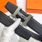 Hermes belt close-up: black leather strap with silver geometric buckle and keeper