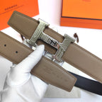Olive leather belt with ornate silver-tone buckle detail and prong hole