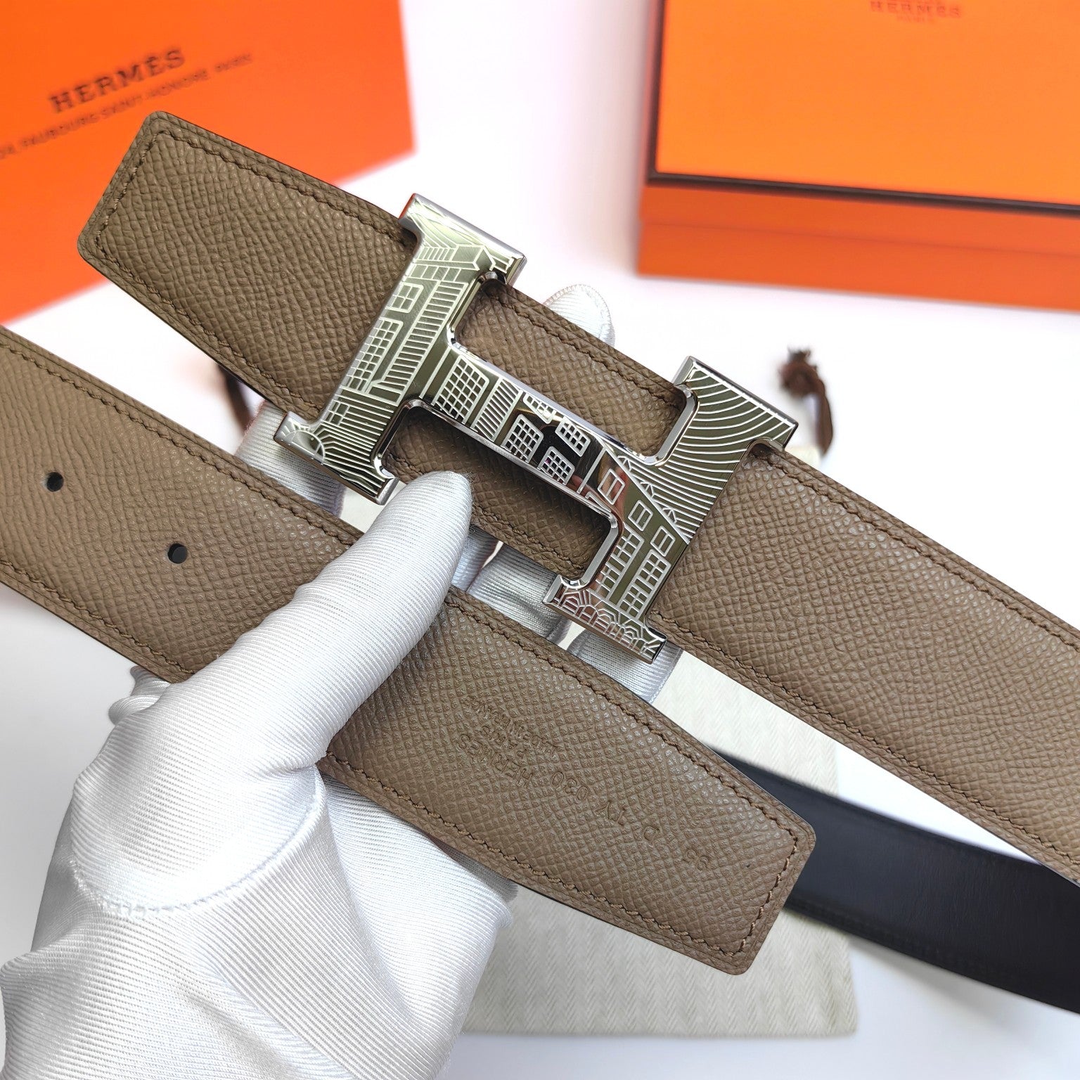 Olive leather belt with ornate silver-tone buckle detail and prong hole