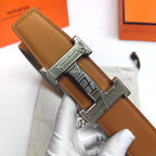 Leather belt with tan textured strap and silver-tone buckle, strap looped