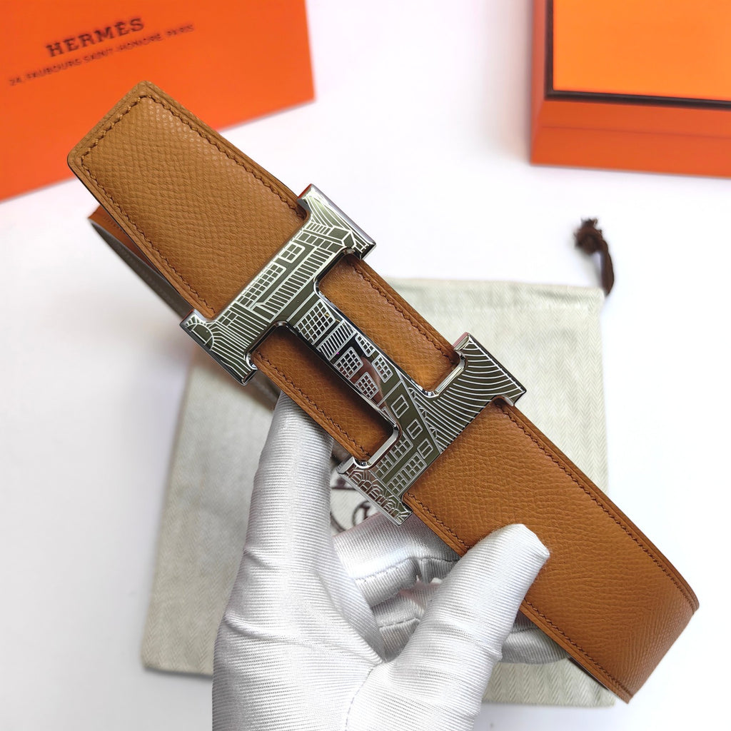 Leather belt with tan strap and large silver-tone buckle, one end with holes