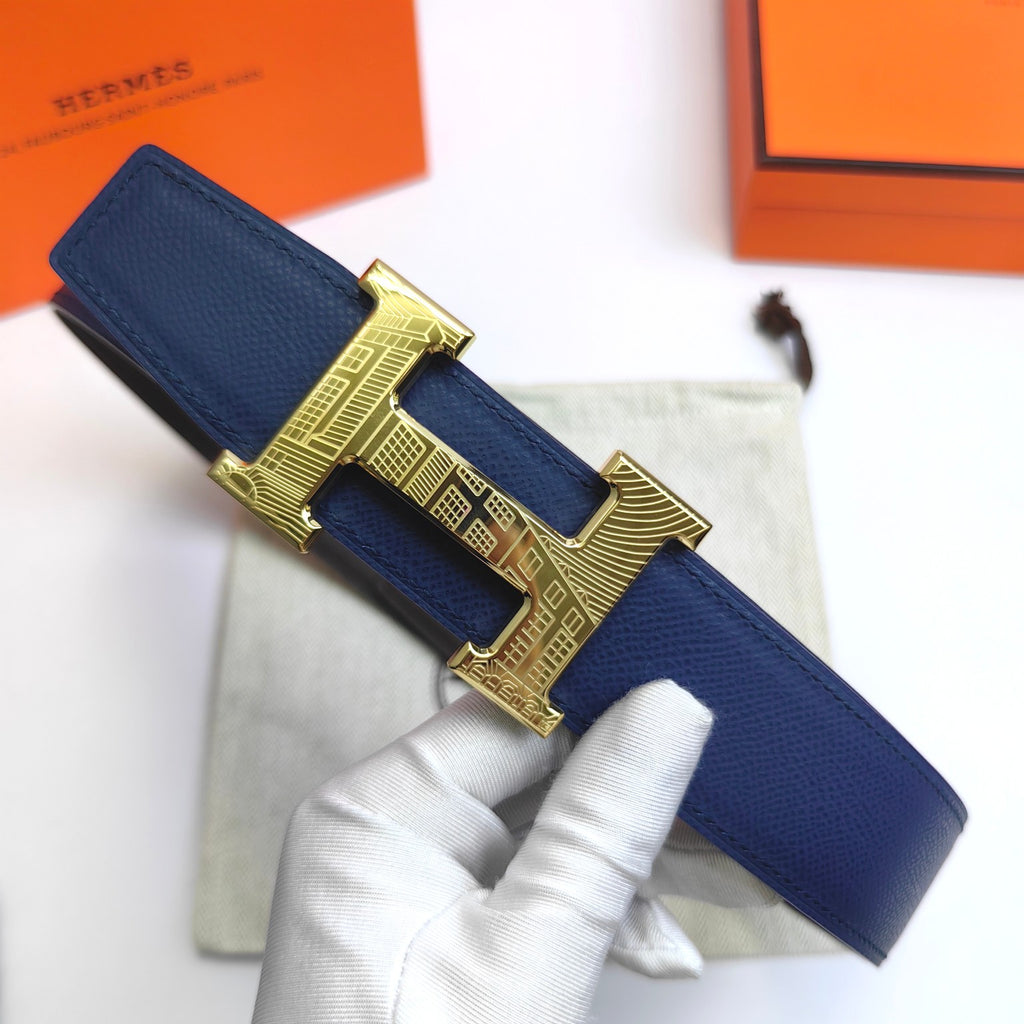 Hermes leather belt with blue strap and gold H buckle, held in hand