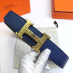 Hermes leather belt with blue strap and gold H buckle, held in hand