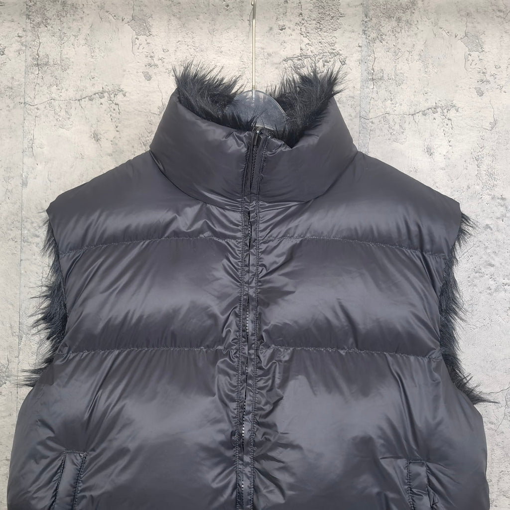 Navy puffer vest close-up with faux-fur collar trim and zip-front quilted design
