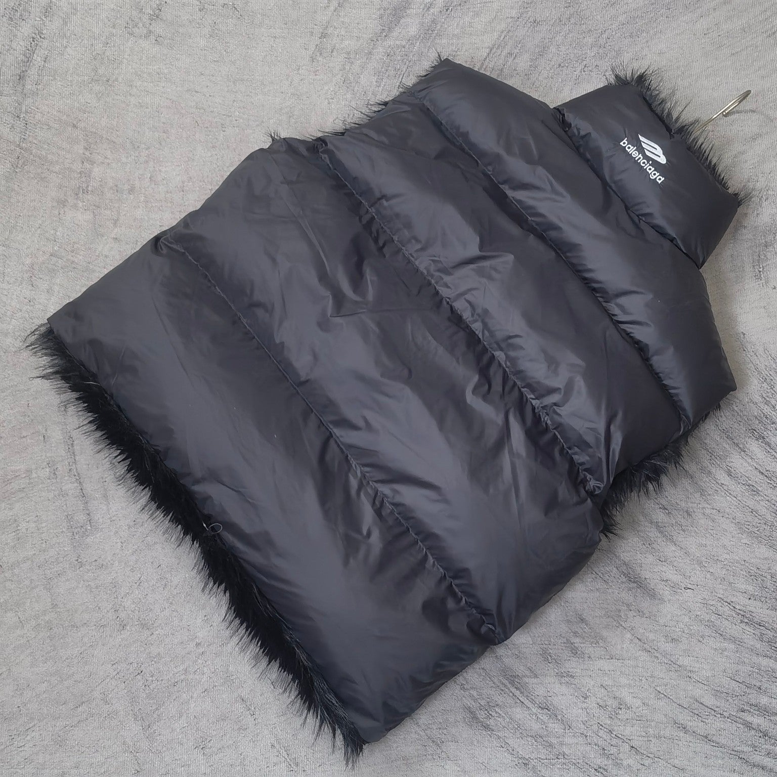 Navy sleeveless puffer vest laid flat with faux-fur trim and side zipper panel