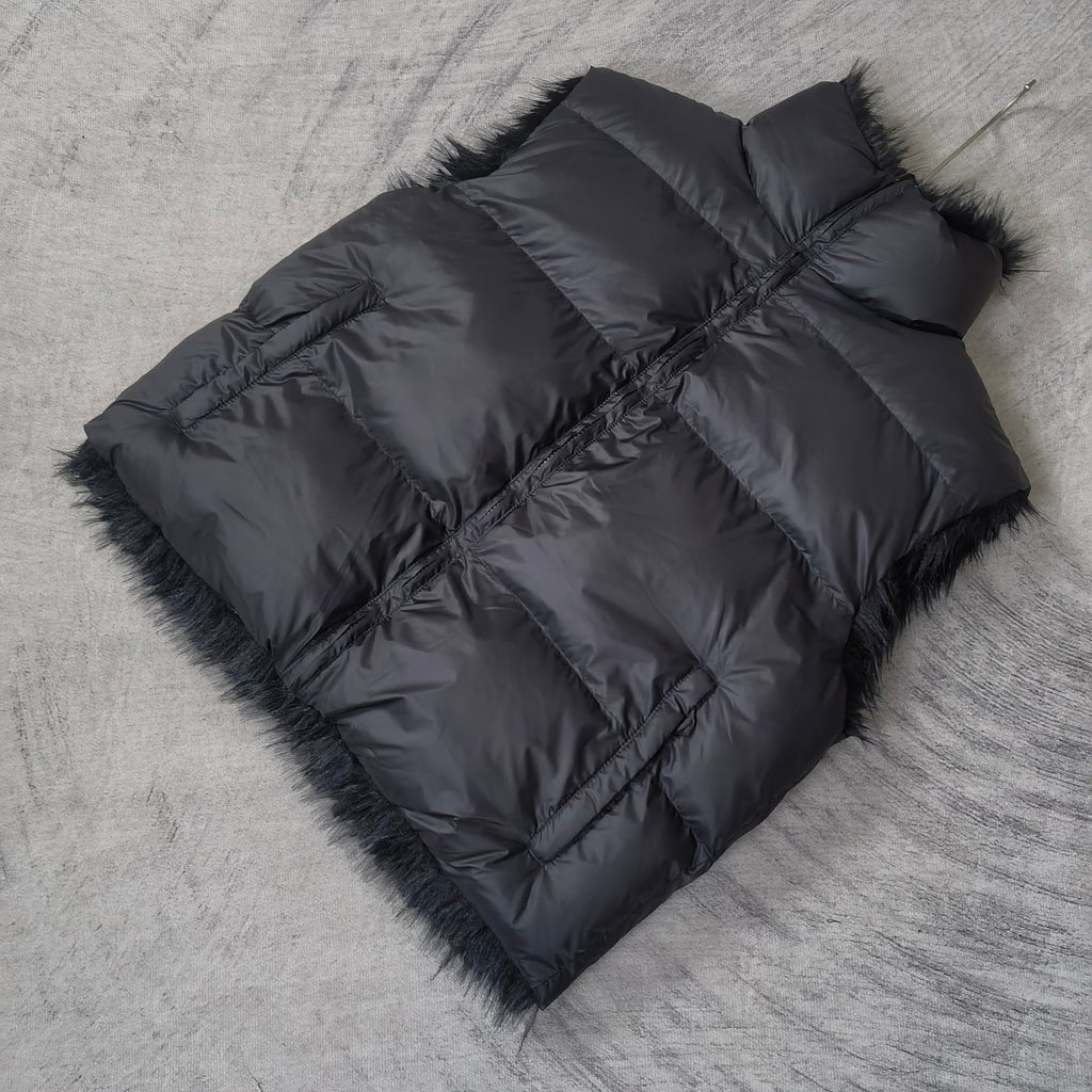 Navy quilted puffer vest laid flat with faux-fur trim and diagonal panel seams