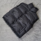 Navy quilted puffer vest laid flat with faux-fur trim and diagonal panel seams