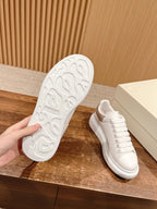 White sneaker outsole with textured tread and lace-up upper, side view.
