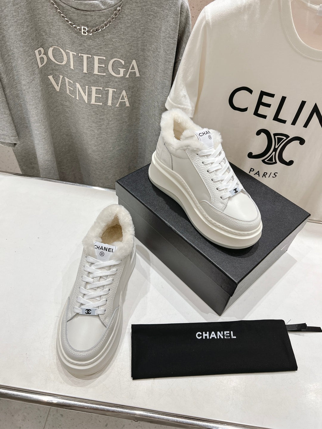 White lace-up sneakers with faux-fur lining collar and Chanel logo, two shoes on boxes