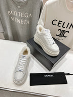 White lace-up sneakers with faux-fur lining collar and Chanel logo, two shoes on boxes