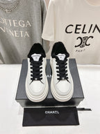 Low-top sneakers in white with black faux-fur collar and black lace-up front