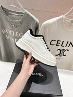 White high-top sneakers with black faux-fur collar, black laces, and side logo