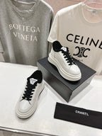 Pair of white low-top sneakers with black faux-fur collar and black lace-up uppers