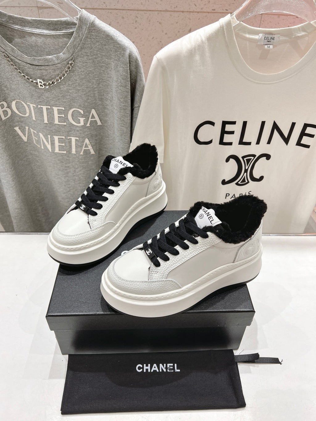 Low-top sneakers with white leather, black faux-fur trim, and black lace-up design