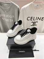 Low-top sneakers with white leather, black faux-fur trim, and black lace-up design