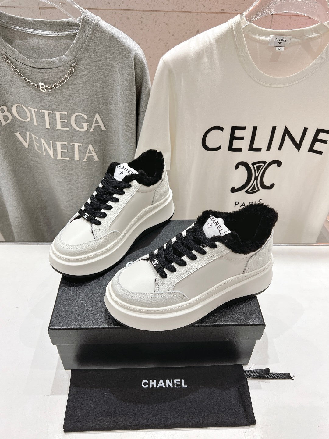 Low-top sneakers with white leather, black faux-fur trim, and black lace-up design