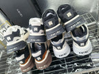 Amiri sneakers display: dark, white, and tan pairs on a metal rack