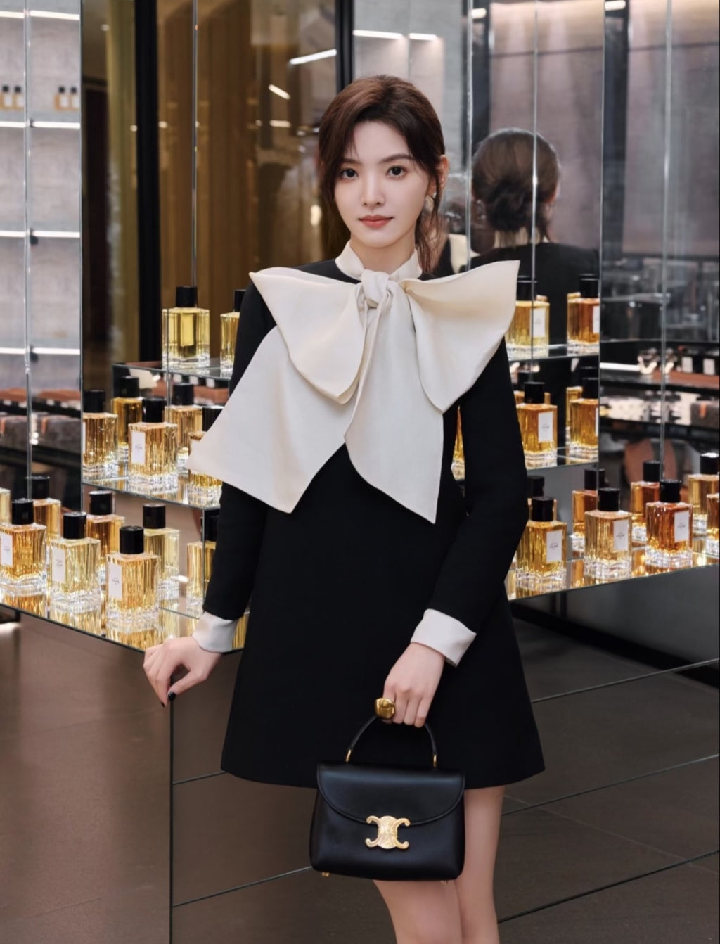 Celine black mini bag with curved front flap, gold logo, and top handles