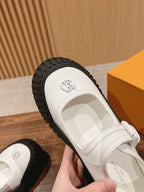 White sneaker close-up: black treaded sole and heel strap with logo