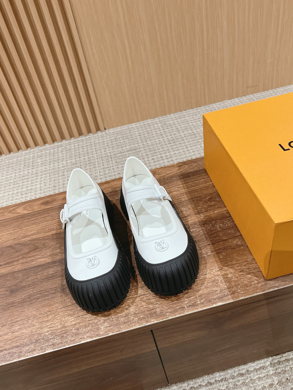 White sneaker with Velcro strap and black ridged rubber sole