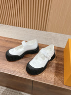 Pair of white sneakers with hook-and-loop straps and black chunky soles