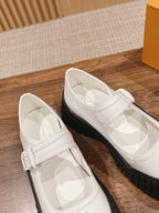 White sneakers with Velcro strap and black rubber soles, side-by-side