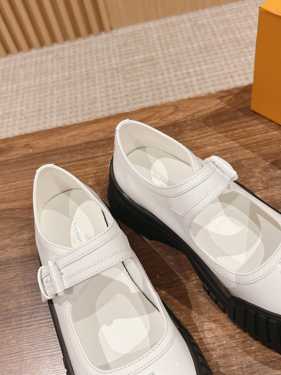 White sneakers with Velcro strap and black rubber soles, side-by-side