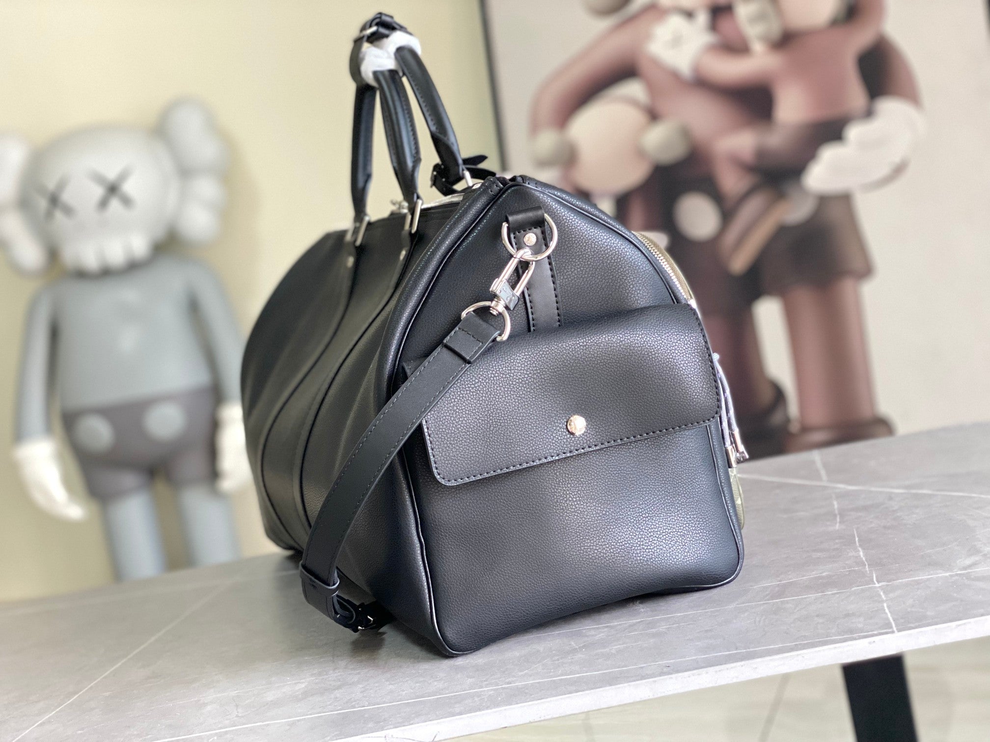 Louis Vuitton handbag in dark blue leather with top handle and front flap hardware.