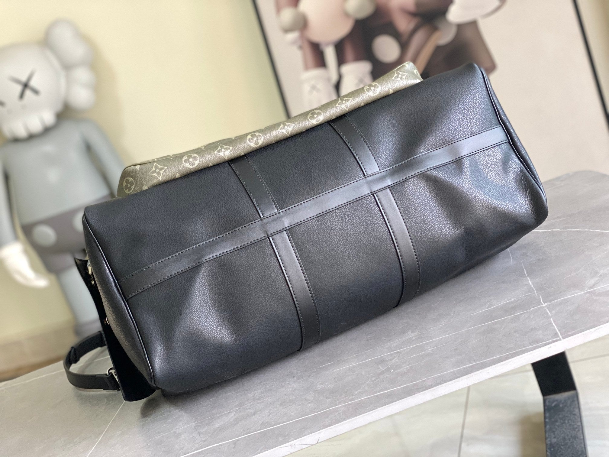 Louis Vuitton men’s duffle bag with black leather body and monogram trim on top edge