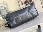 Louis Vuitton duffel bag with black leather body and monogram canvas top panel.
