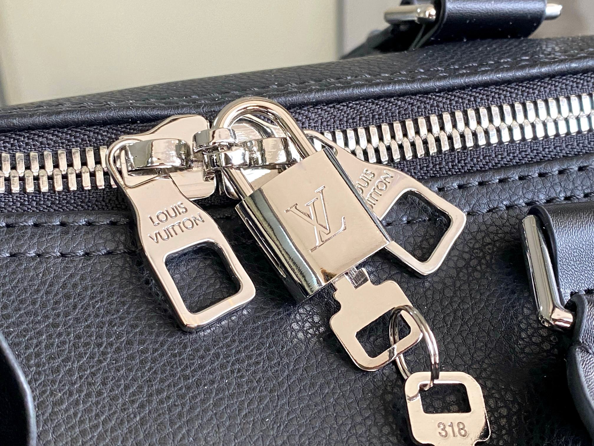 Louis Vuitton men’s duffle bag close-up of silver zipper pull and buckle hardware