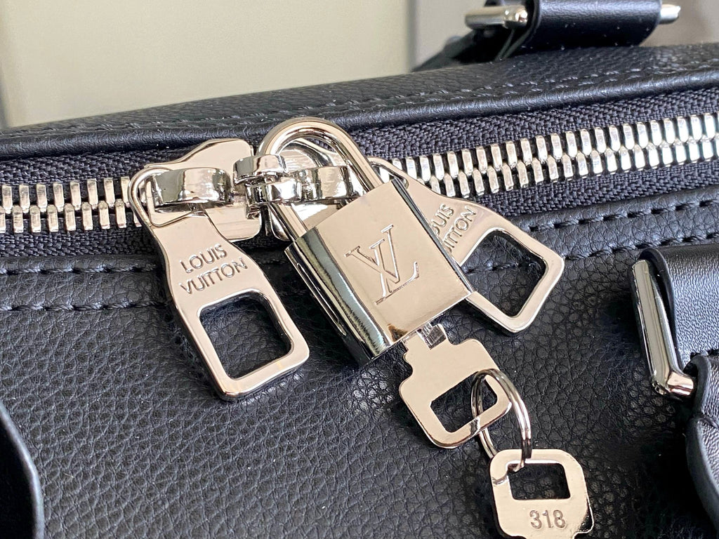 Louis Vuitton zipper pull hardware on black leather bag with logo engraved pieces.