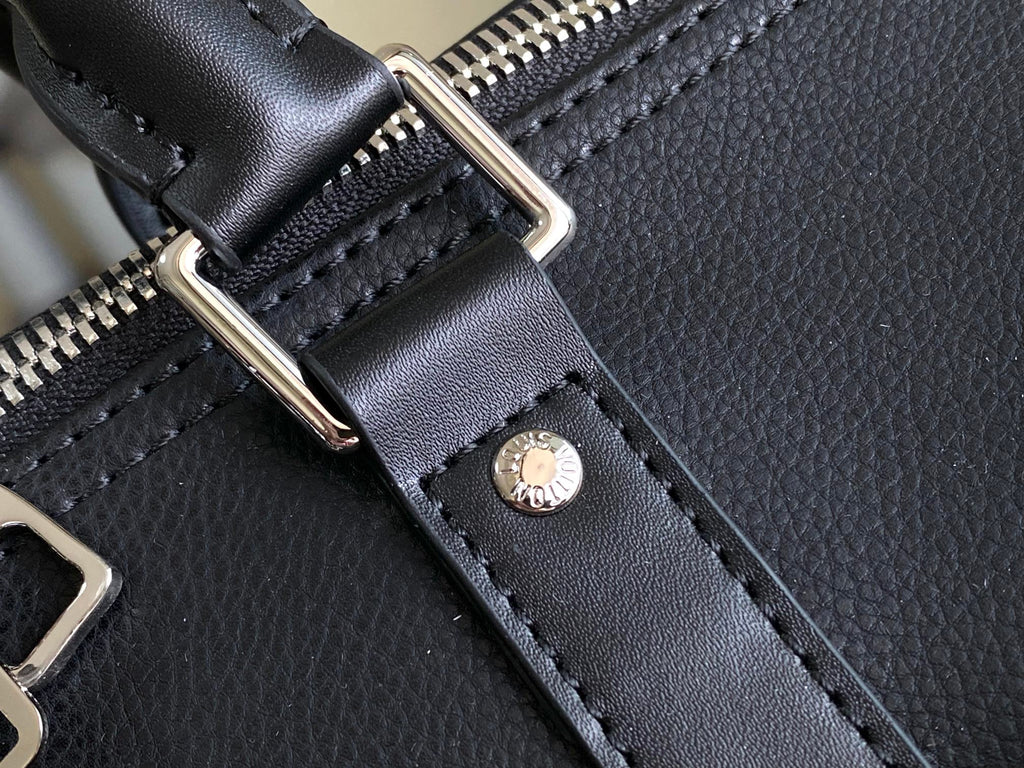 Louis Vuitton men’s duffle bag close-up of silver zipper track and black leather strap tab