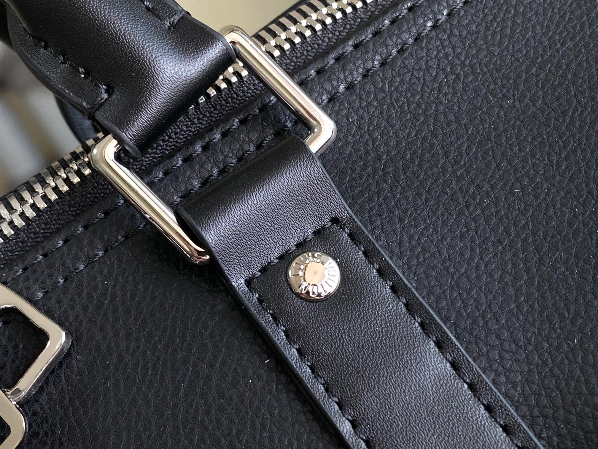 Louis Vuitton men’s duffle bag close-up of silver zipper track and black leather strap tab